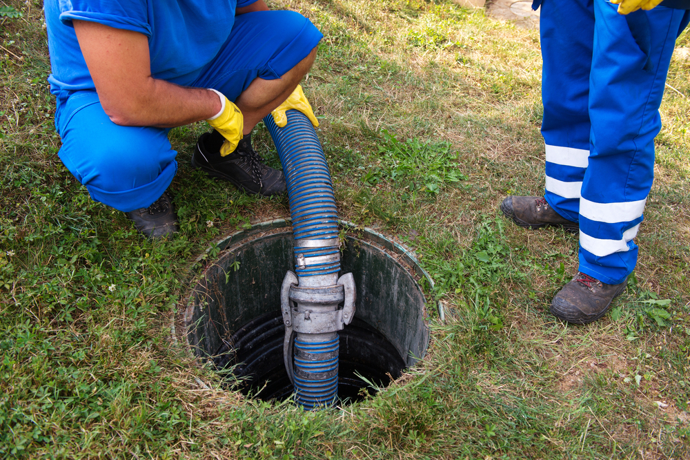 Man emptying septic tank with hose